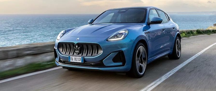 A 2025 Maserati Grecale Folgore drives by the beach.